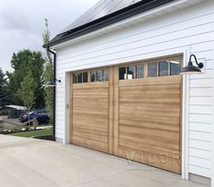 two wooden garage doors on the side of a house