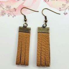 These charming Tan grain leather earrings are 1-3/4  inch long.  That is the length of the leather. Please see photos for the overall length.  They have a pretty antique bronze cap that will also give attention to these sophisticated earrings. They are lightweight, you will forget that you are wearing them. I would suggest keeping them out of water. Leather tends to get spotted and can shrink.  They are suited for sensitive ears.  *Nickle free hooks  **USUALLY SHIPS NEXT DAY  PLEASE SEE PHOTOS FOR TOTAL LENGTH. GET COMPLIMENTS🥰 They look good with casual clothes, and work clothes. They can also dress up the look of your outfit because of the pretty end caps.   I'm sure you will get plenty of compliments! They also make great  gifts for someone special like your Bestie, Mom, daughter Aunt Rustic Brown Brass Earrings, Vintage Brown Earrings For Everyday, Rustic Brown Adjustable Earrings, Handmade Brown Earrings, Sophisticated Earrings, Sensitive Ears, Leather Earrings, Favorite Dress, You Are Awesome