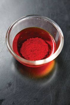 a glass bowl filled with red dye on top of a table