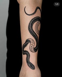 a black and white snake tattoo on the arm