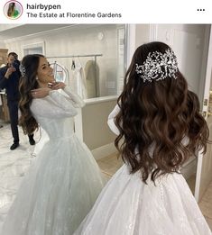 a woman in a wedding dress looking at herself in the mirror