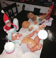 an assortment of baby dolls and toys on a table