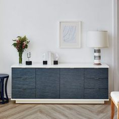 a white and blue dresser in a room with a lamp on it's side