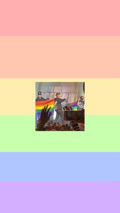 an image of a person holding their hand up in front of a rainbow colored background