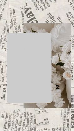 a photo frame sitting on top of newspaper with white flowers in the middle and an empty space for text