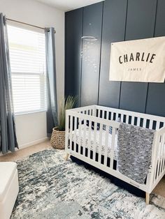 a baby's room with blue walls and white crib in the corner, along with a large rug on the floor