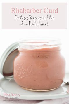 a jar filled with pink liquid sitting on top of a white plate