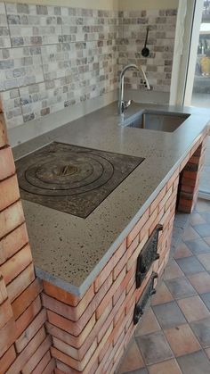 a kitchen counter made out of bricks with a sink and faucet in the middle