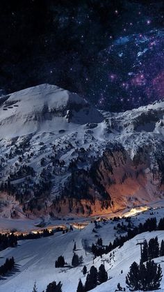 the night sky is filled with stars and lights as seen from a snowy mountaintop