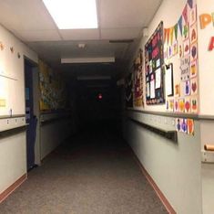 an empty hallway with posters on the wall