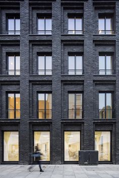 a person walking in front of a tall building