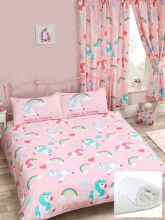 a pink bed with unicorns and rainbows on it in front of a window