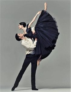 two ballerinas in black and white posing for the camera with their arms around each other