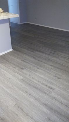 an empty kitchen and living room with wood flooring