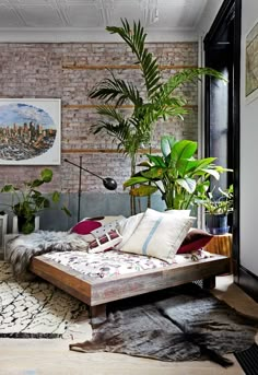 a bedroom with brick walls and lots of plants in the corner, including a bed