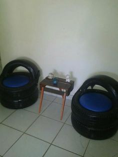 two black tires sitting on top of a white tiled floor next to a small table