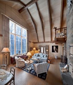 a living room filled with furniture and a fire place in front of a large window