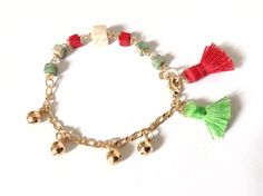 "Christmas Bell Bracelet This delicate 6.05\" boho bracelet is made with 5mm square natural stone beads, twisted by hand with gold filled wire. On one side of the bracelet, it has five tiny bells that ring to move and ends up with two delicate 1cm tassels red and green color reminiscent of Christmas. It is a customizable perfect layering piece for Christmas season. A solid gold plated lobster clasp makes for easy and secure closure and a gold plated extension chain makes the bracelet adjustable Bohemian Round Bead Bracelets For Holiday, Bohemian Adjustable Bracelets For Festive Occasions, Adjustable Bohemian Bracelets For Festive Occasions, Bohemian Bracelets With Dangling Beads For Gift, Adjustable Multicolor Bracelets With Dangling Beads, Adjustable Tassel Bracelets As Gifts, Bohemian Adjustable Bracelets For Holiday, Bohemian Style Adjustable Holiday Bracelets, Adjustable Bohemian Jewelry For Holiday