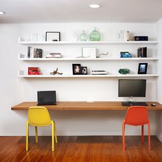 two chairs are sitting in front of a desk with a laptop and monitor on it