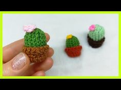 small crocheted cactus and succulents are being held by someone's hand