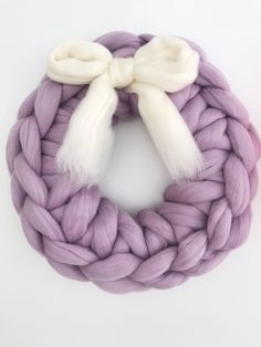 a purple and white yarn wreath on a white background