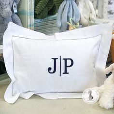 a stuffed animal next to a pillow with the word j p on it