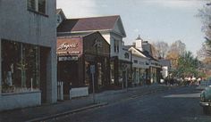 an old photo of a city street with cars parked on the side