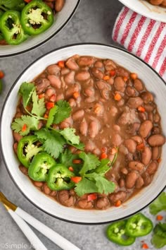 two white bowls filled with beans and vegetables