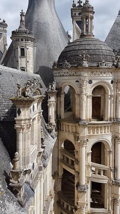 an old building with two towers and some other buildings in the backrounds