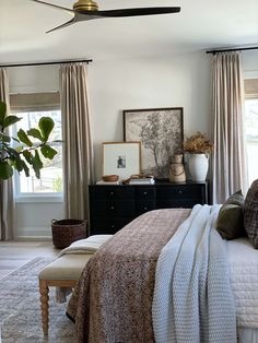 a bedroom with a bed, dresser, and window in it's center area