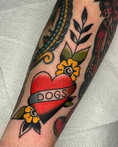 a person with a tattoo on their arm holding a dog's heart and flowers