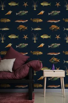 a living room with a couch, table and wallpaper that has fish on it