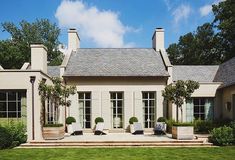 a large white house sitting on top of a lush green field