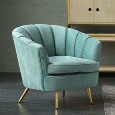 a blue chair sitting on top of a hard wood floor next to a wooden dresser