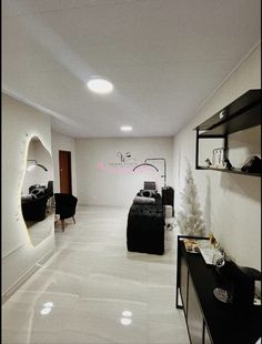 a living room filled with black furniture and white walls