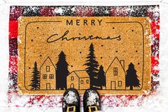 a pair of black shoes sitting on top of a snow covered ground next to a merry christmas door mat