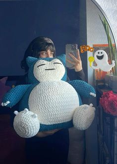 a woman holding a large stuffed animal in front of a mirror