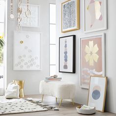 a living room filled with lots of pictures and art hanging on the wall next to a coffee table