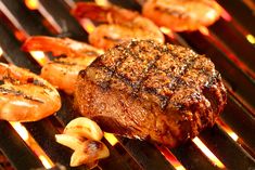 steak and shrimp cooking on an outdoor grill