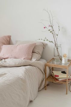 a bedroom with a bed, side table and flowers