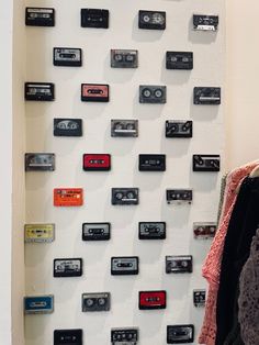 there are many cassettes on the wall and one has a coat rack in front of it