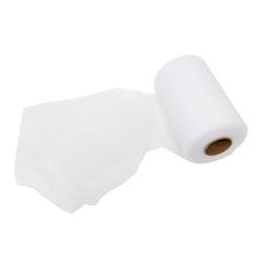 a roll of white toilet paper sitting on top of a piece of plastic wrapper