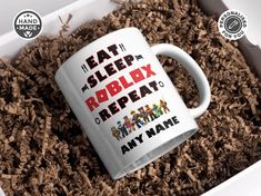 a white coffee mug with the words eat sleep roblox repeat on it surrounded by wood shavings