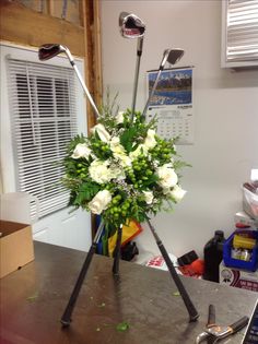 a vase filled with white flowers and golf clubs