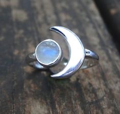 Handmade, Natural Rainbow Moonstone Sterling Silver Ring 💙Featured in this listing are sterling silver, handmade, natural stone rings. These lovely rings feature a beautiful, Natural Rainbow Moonstone 7mm round stone. The Glowing stone has been bezel set into a handcrafted, adjustable setting made with all highly polished Sterling Silver. A handcrafted Crescent Moon sits aside the Moonstone and is 11x15mm. Each Rainbow Moonstone has been handpicked, and have amazing flash! 🌜Please keep in mind Silver Moonstone Ring With Moon Phase, Spiritual Sterling Silver Moonstone Ring With Moon Phase, Silver Crescent Moonstone Ring In Celestial Style, Silver Celestial Moonstone Ring, Celestial Sterling Silver Moonstone Open Ring, Celestial Sterling Silver Moonstone Ring Gift, Silver Moon-shaped Celestial Moonstone Ring, Celestial Silver Moonstone Ring, Moon-shaped Sterling Silver Moonstone Ring As Gift