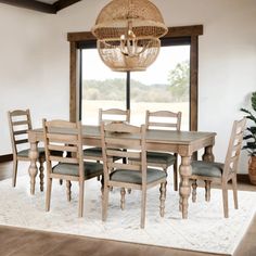 a dining room table with six chairs and a chandelier hanging from the ceiling