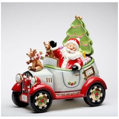 a santa clause riding in a red car with reindeers on it's back