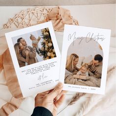 two christmas cards are held up in front of a woman and her baby on a bed