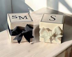 two boxes with bows are sitting on a table