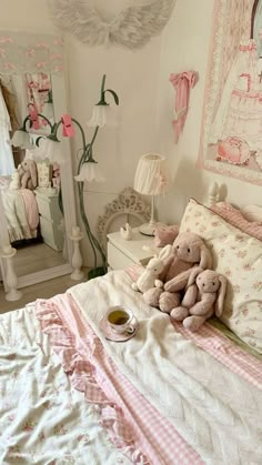 a teddy bear sitting on top of a bed next to a cup of coffee in front of a mirror